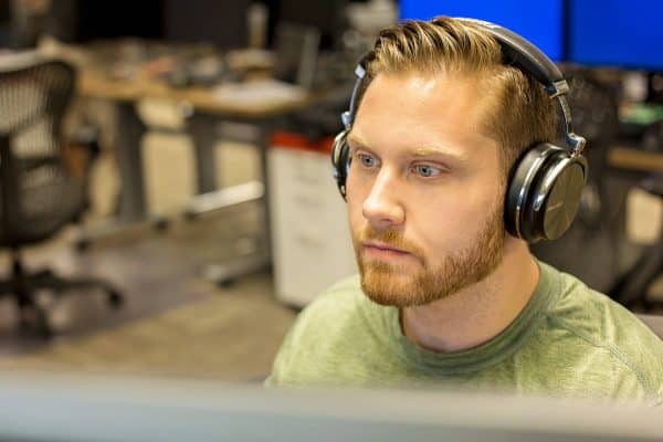 Man in green shirt looking at monitor