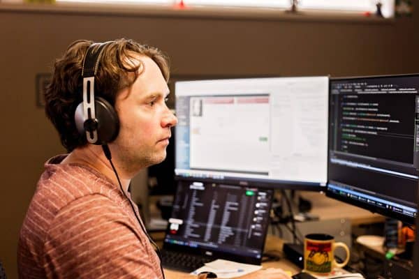 Man in red shirt looking at monitor