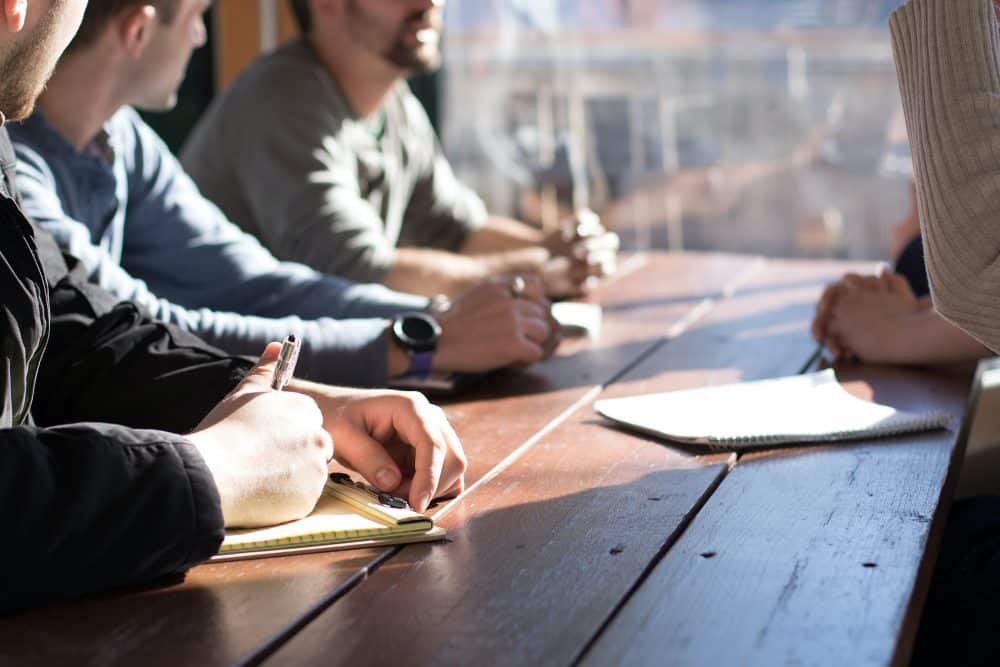 People sitting around wood table