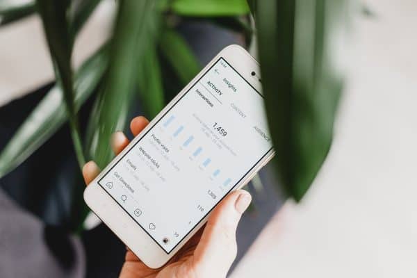 person holding a phone displaying analytics