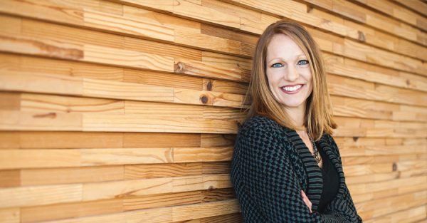 Woman leaning against wooden wall