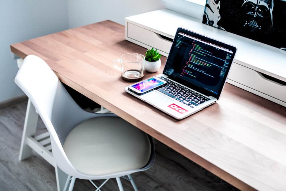 Laptop on wood table with code displayed