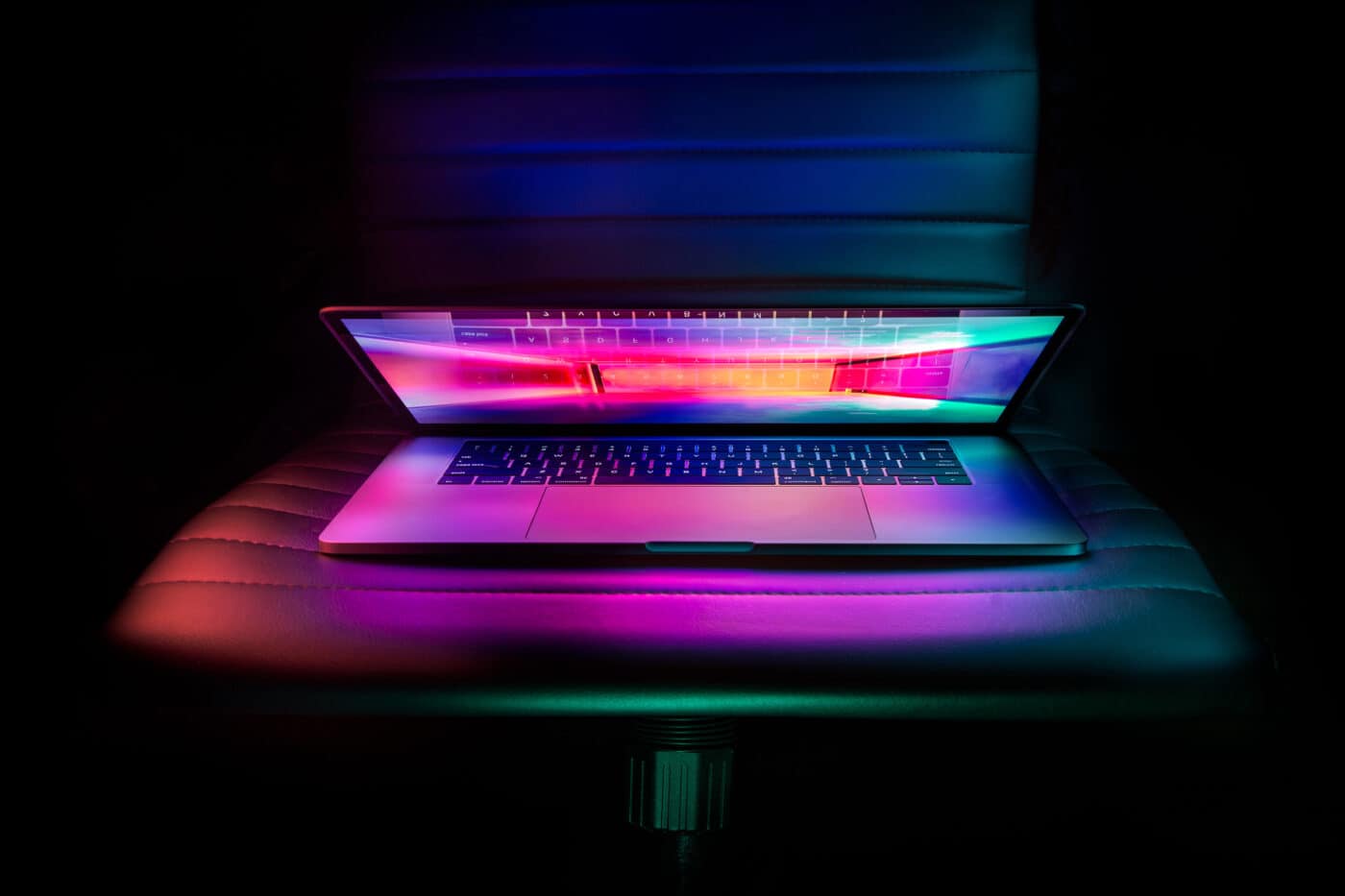 Laptop half closed with neon colors on the screen