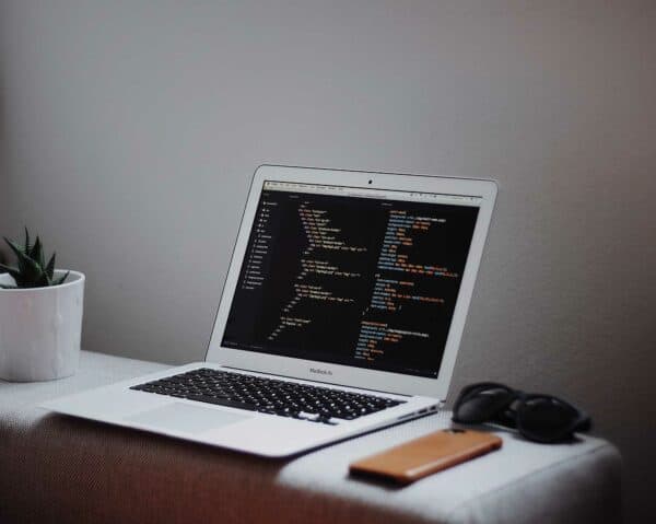 Laptop displaying code sitting on a desk