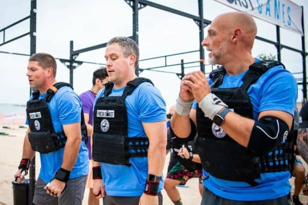 Three men doing CrossFit on the beach