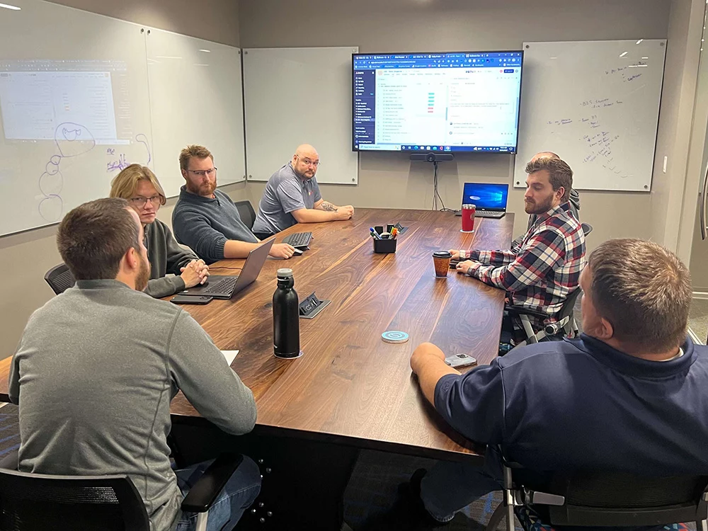 Group of BizStream team members sitting around a wood conference table