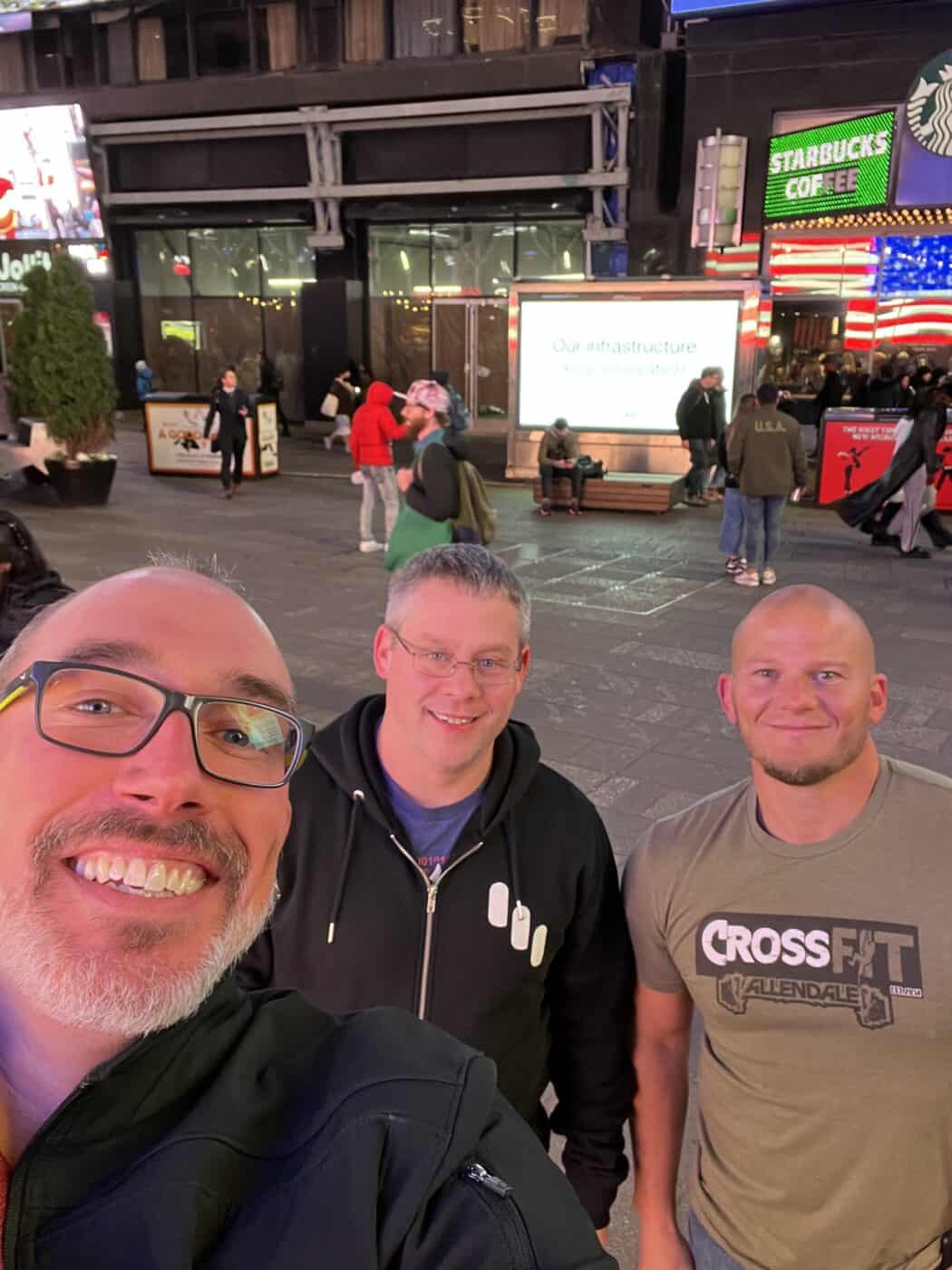 Three men standing in Times Square