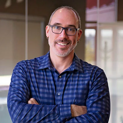 man wearing blue button up shirt and glasses