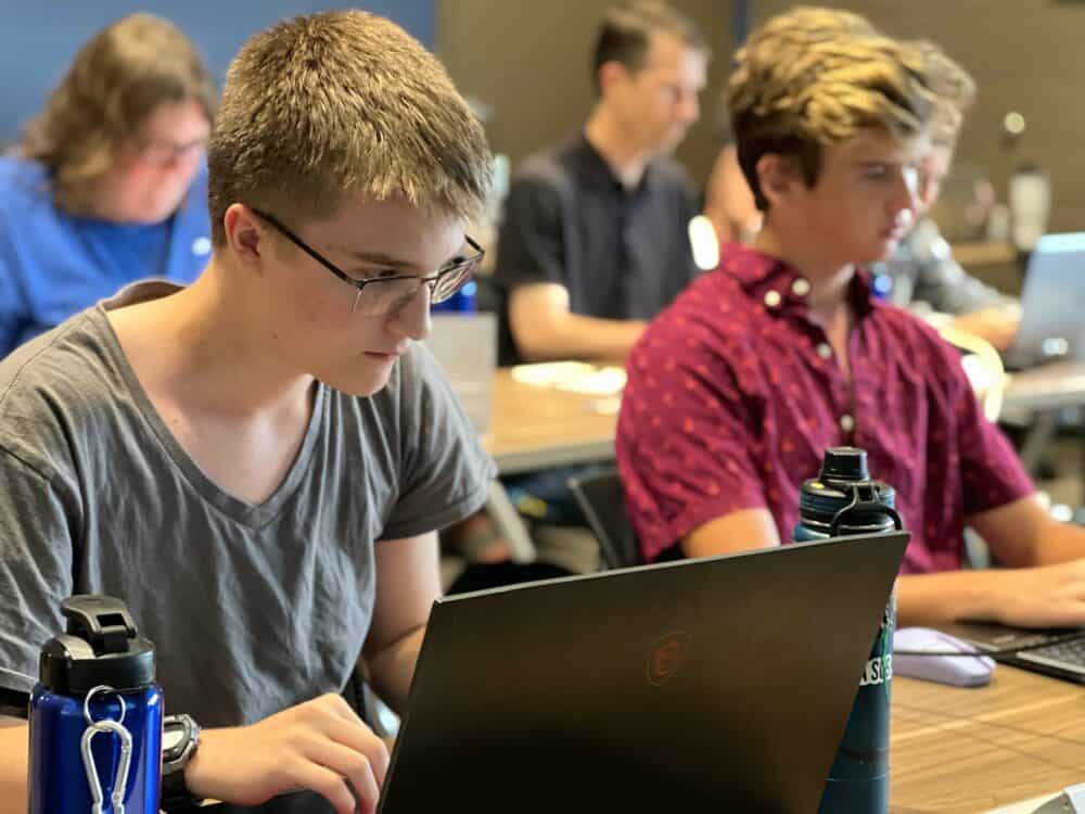 Two kids looking a laptops