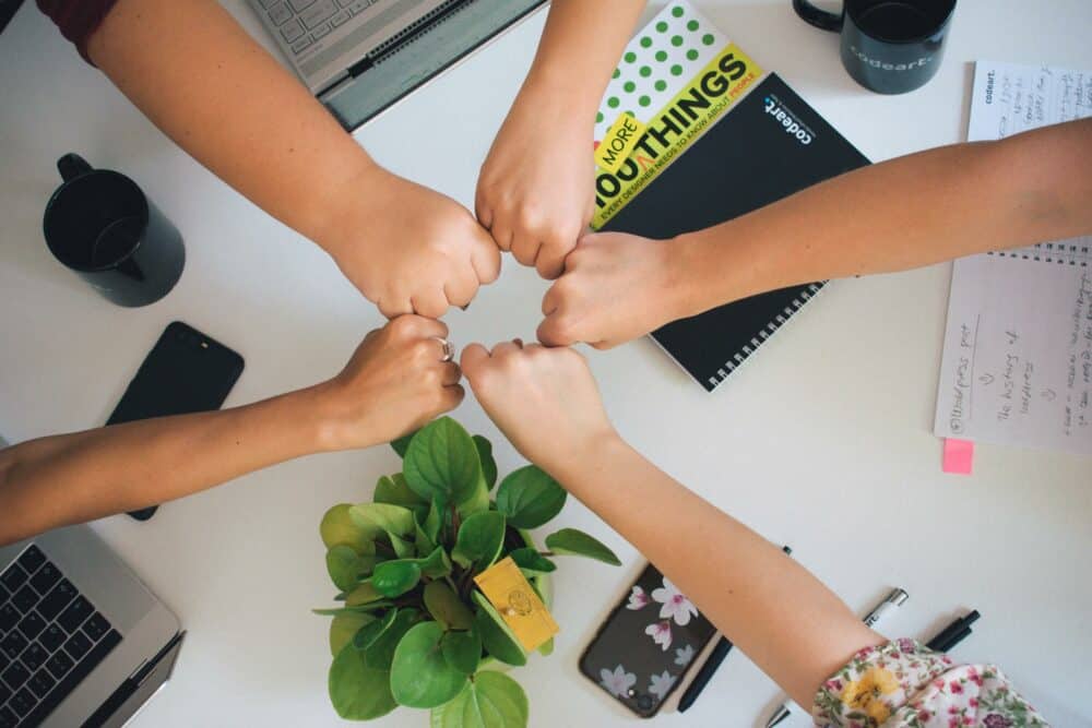 five people fist bumping