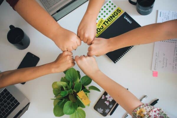 five people fist bumping