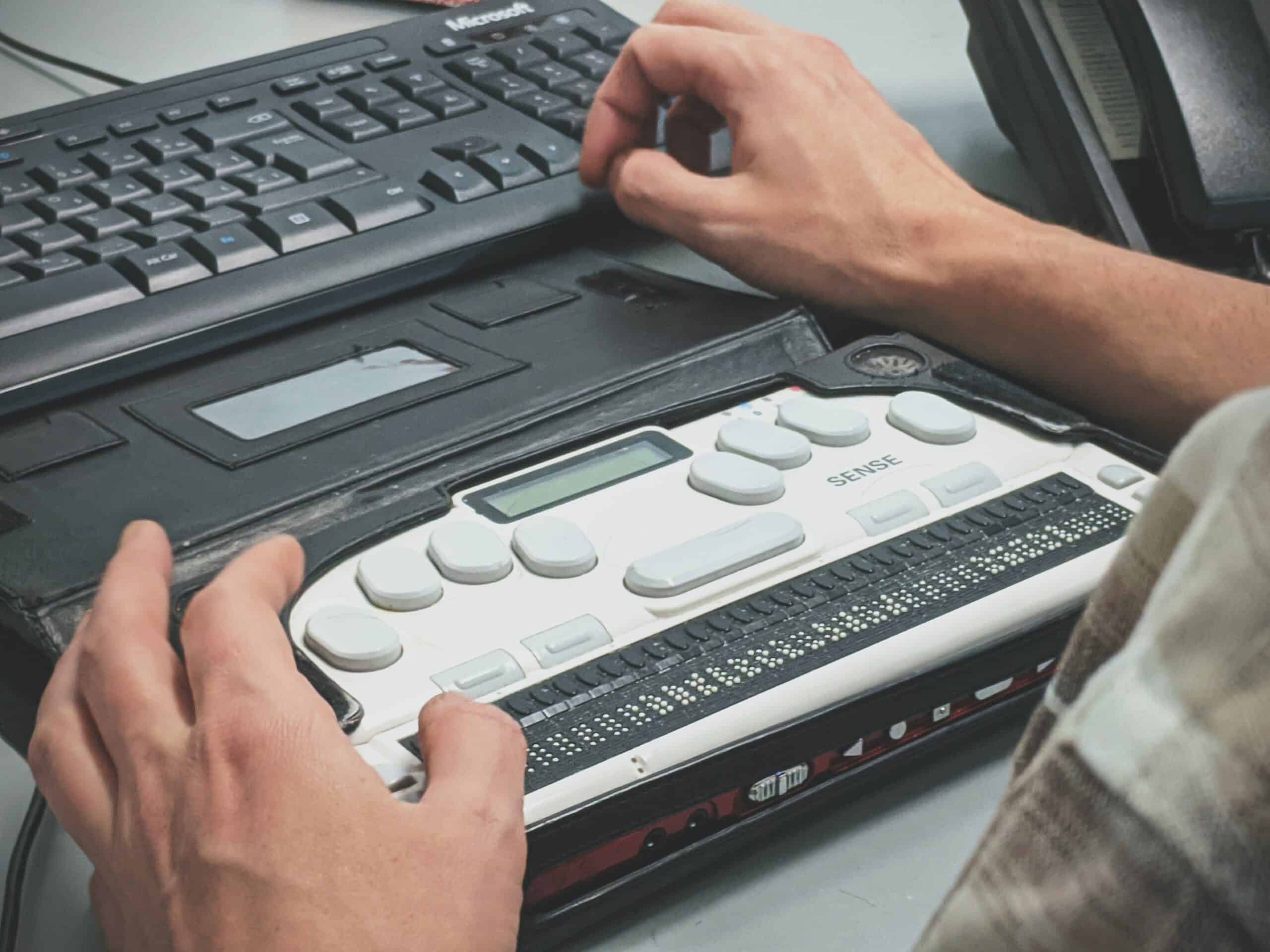 Blind man using a braille screen reader.