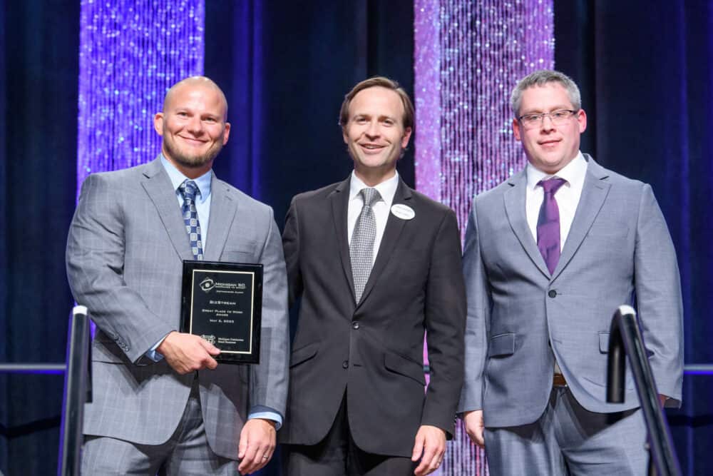 Three men in suits at an awards gala