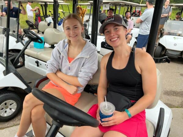 Two women in a golf cart