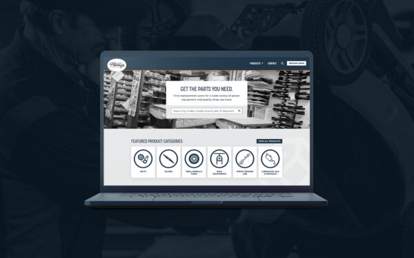 Image of a laptop displaying a monochrome website homepage for a transportation or logistics company. The design includes a central banner with text, a search feature, and icons representing services such as tracking, logistics, and support, set against an industrial background image.