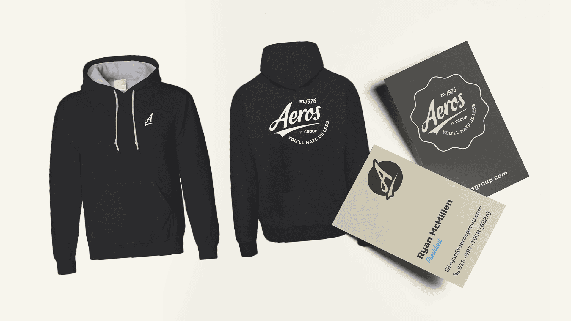 Branded Aeros IT Group merchandise including a black hoodie with the company logo on the front and back, and business cards featuring the logo and contact details.