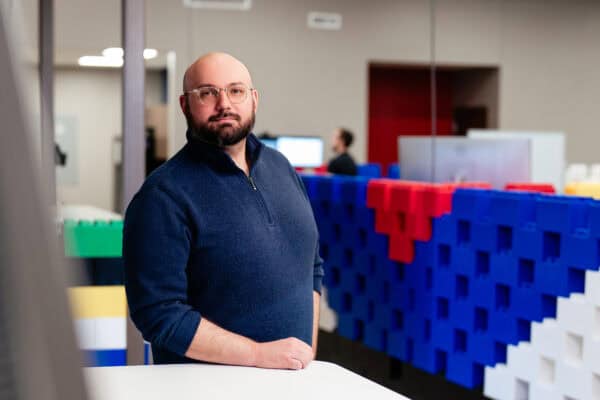 Man standing by a table in front of a divider wall