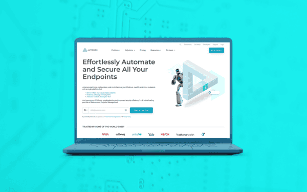 A laptop displaying the Automox website homepage, featuring a headline that reads 'Effortlessly Automate and Secure All Your Endpoints.' The page includes a call-to-action button for starting a free trial, a futuristic robot graphic, and logos of well-known companies such as NASA, Xerox, and Yale. The background is a bright cyan color with a subtle circuit board pattern.