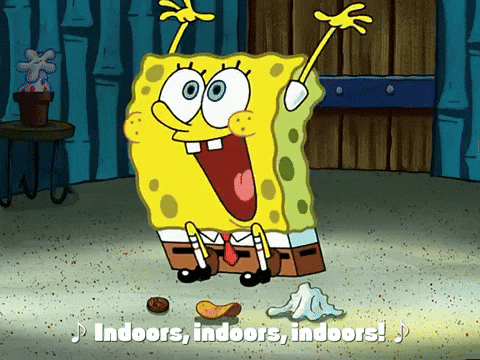 Excited SpongeBob sits on the floor with arms raised, singing joyfully, “Indoors, indoors, indoors!” with a peanut, chip, and tissue in front of him.