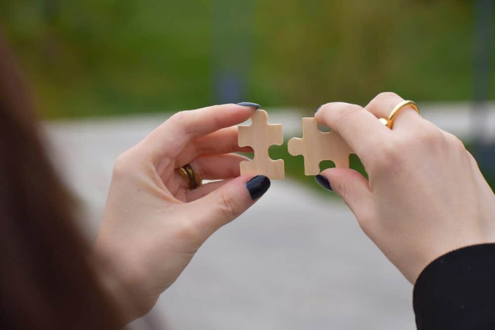 Business partnership concept, woman hands holding 2 pieces of puzzle