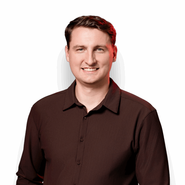 Josh Forner smiling in glasses and a dark sweater.