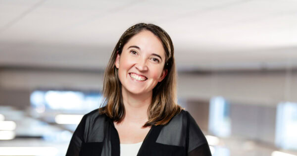Close-up of Theresa Lawrence smiling warmly in a well-lit office environment.