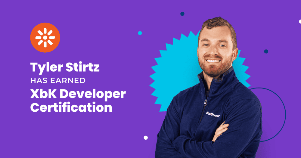 Tyler Stirtz smiling with arms crossed in a BizStream quarter-zip next to the Kentico logo and the text “Tyler Stirtz has earned XbK Developer Certification.”