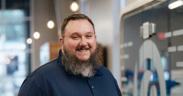Smiling man with a beard in a professional setting at BizStream.
