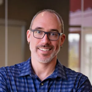 man wearing blue button up shirt and glasses